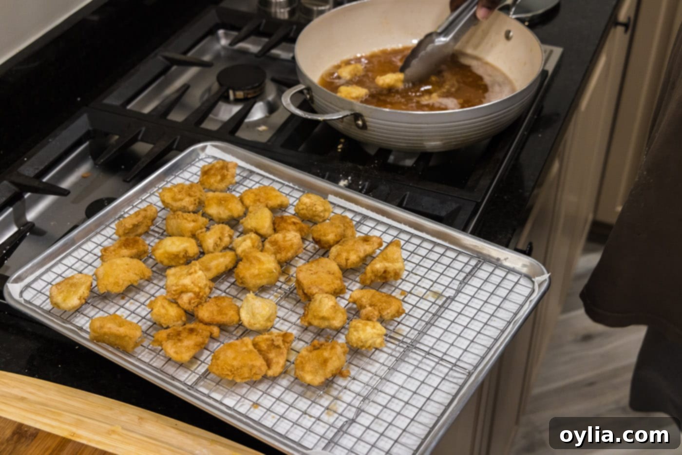 fried chicken cubes draining on a wire rack