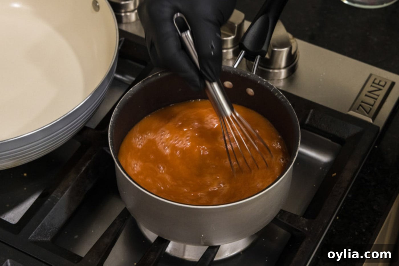whisking sweet and sour sauce in a saucepan