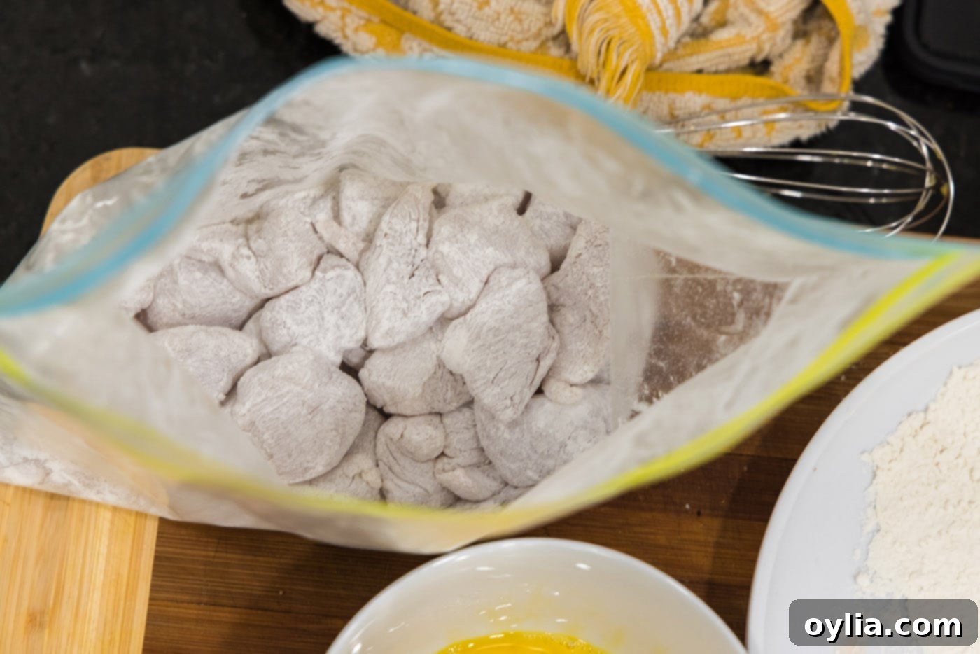 cubed chicken coated in cornstarch in a bag
