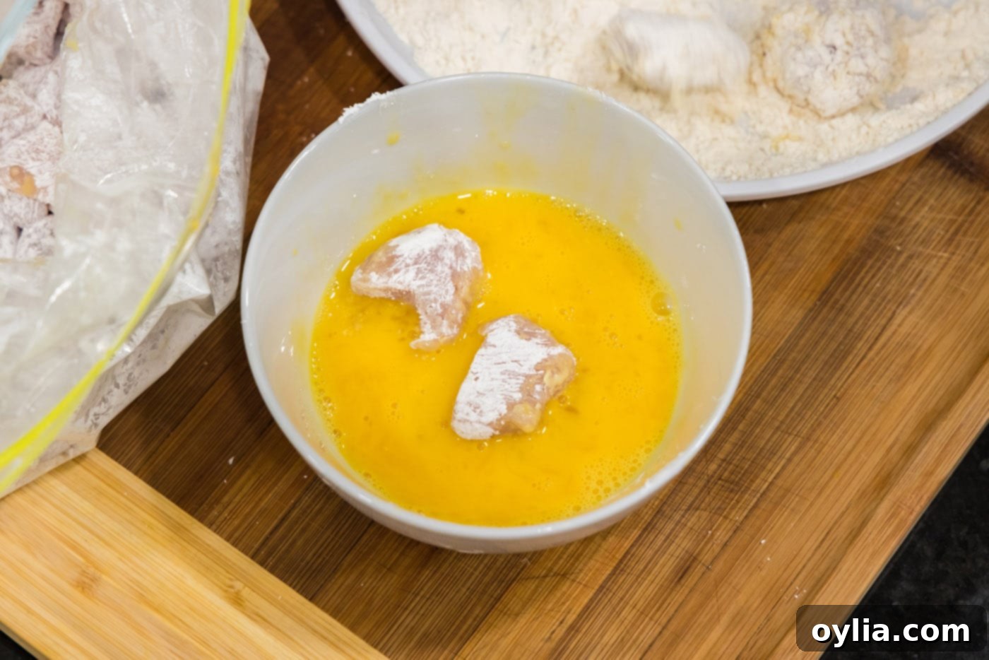 dipping cornstarch coated chicken in whisked eggs