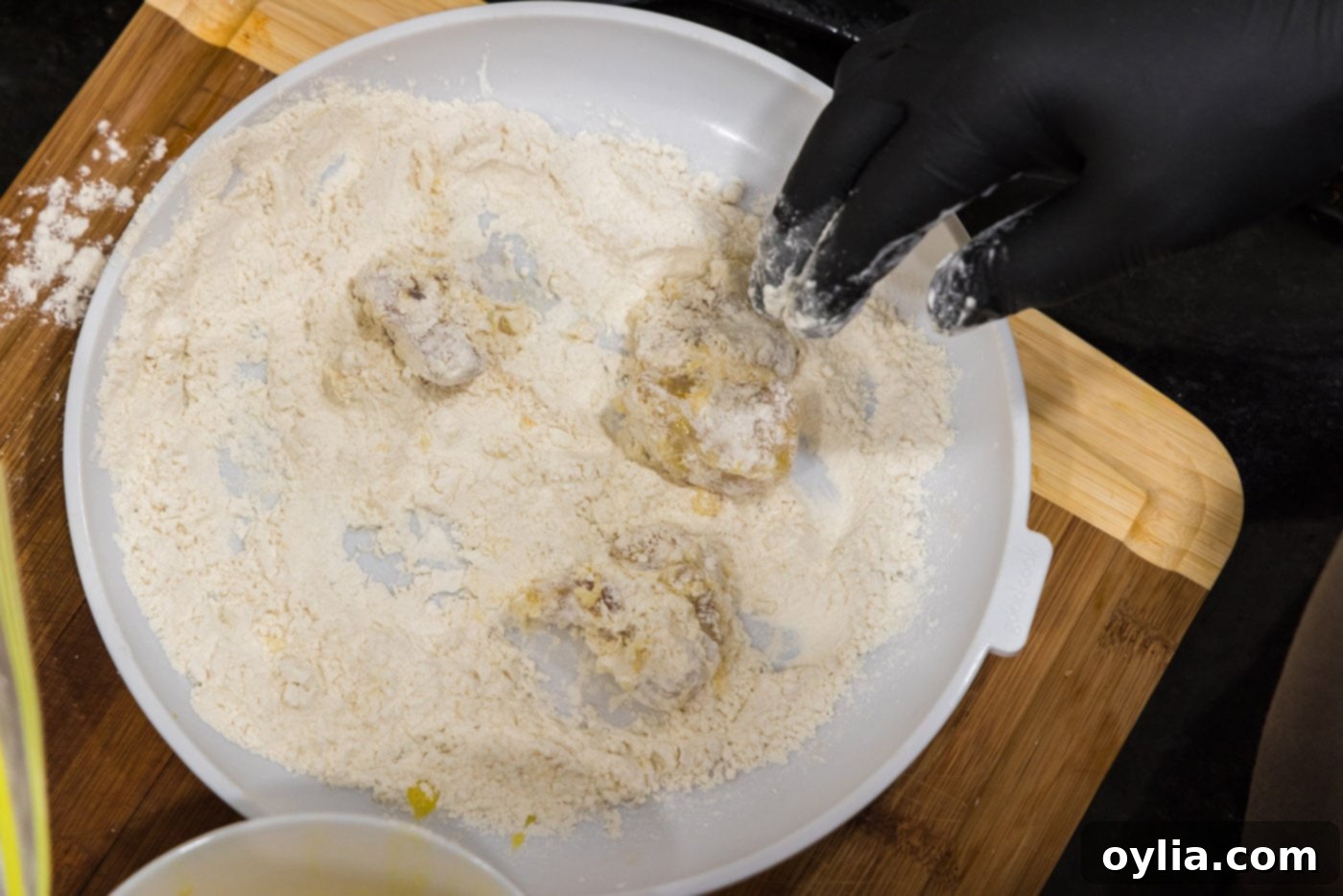 tossing dredged chicken cubes in flour