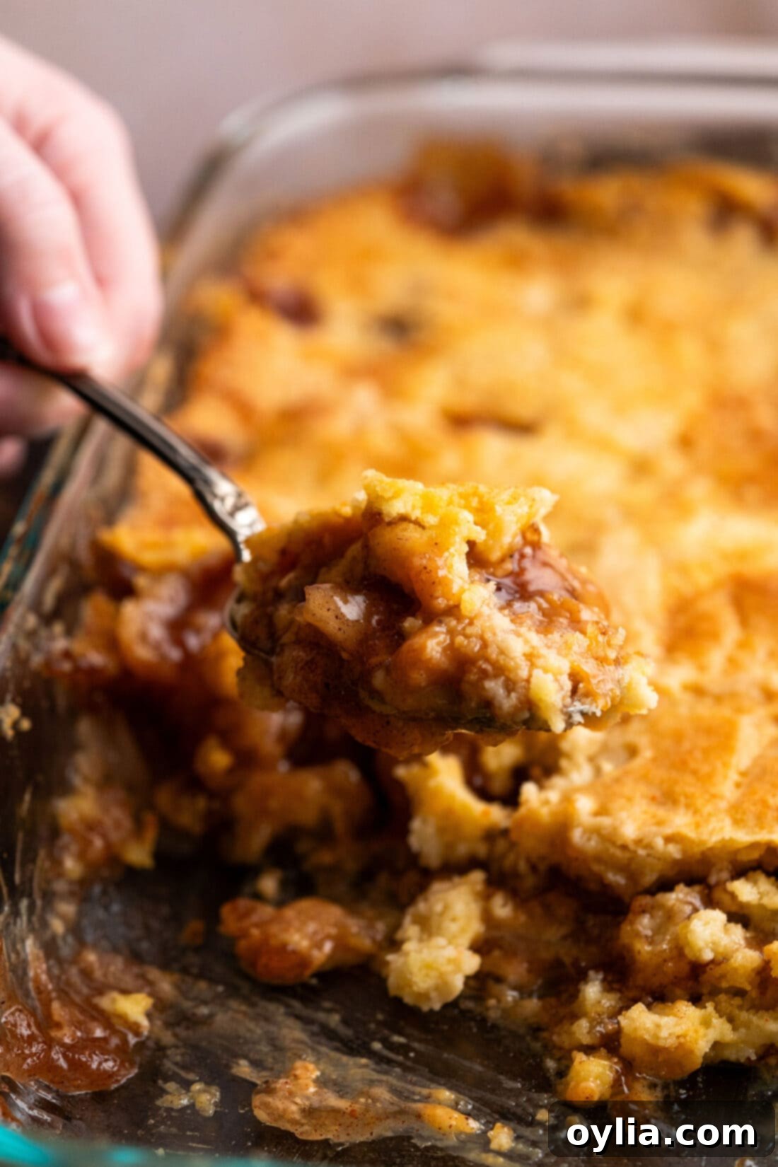 One Pan Caramel Apple Bliss 3 Scoop of Caramel Apple Dump Cake being lifted out of the pan