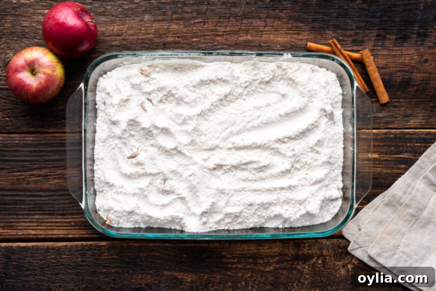 dry cake mix on top of apple pie filling in a baking dish