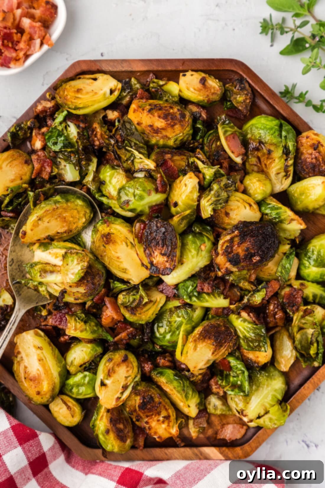 Close up photo of Brussels Sprouts with Bacon, Shallots and Candied Pecans on a wooden platter