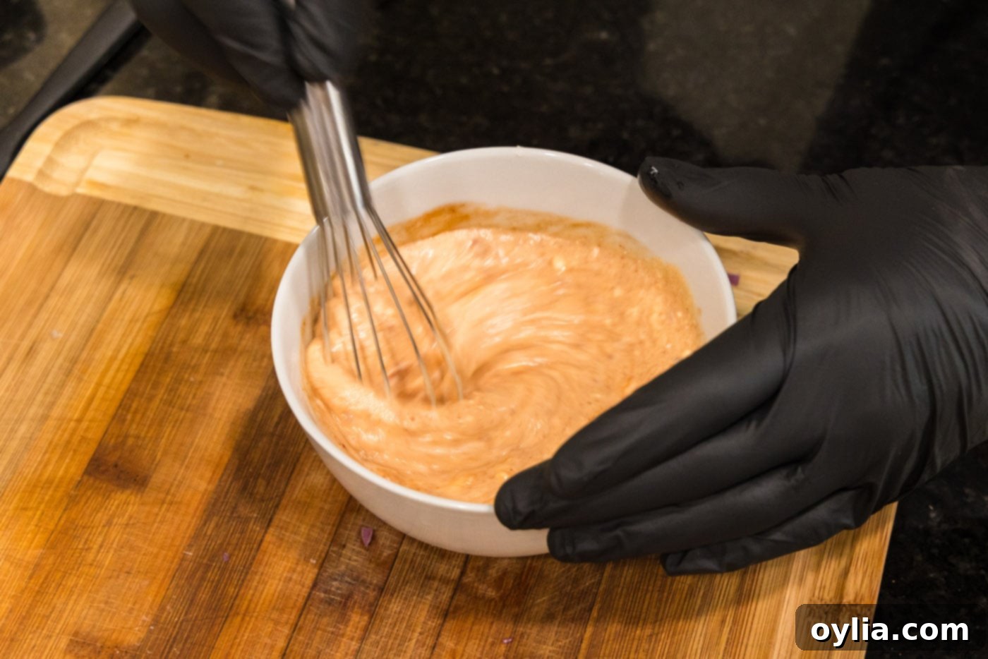 whisking bang bang sauce in a bowl
