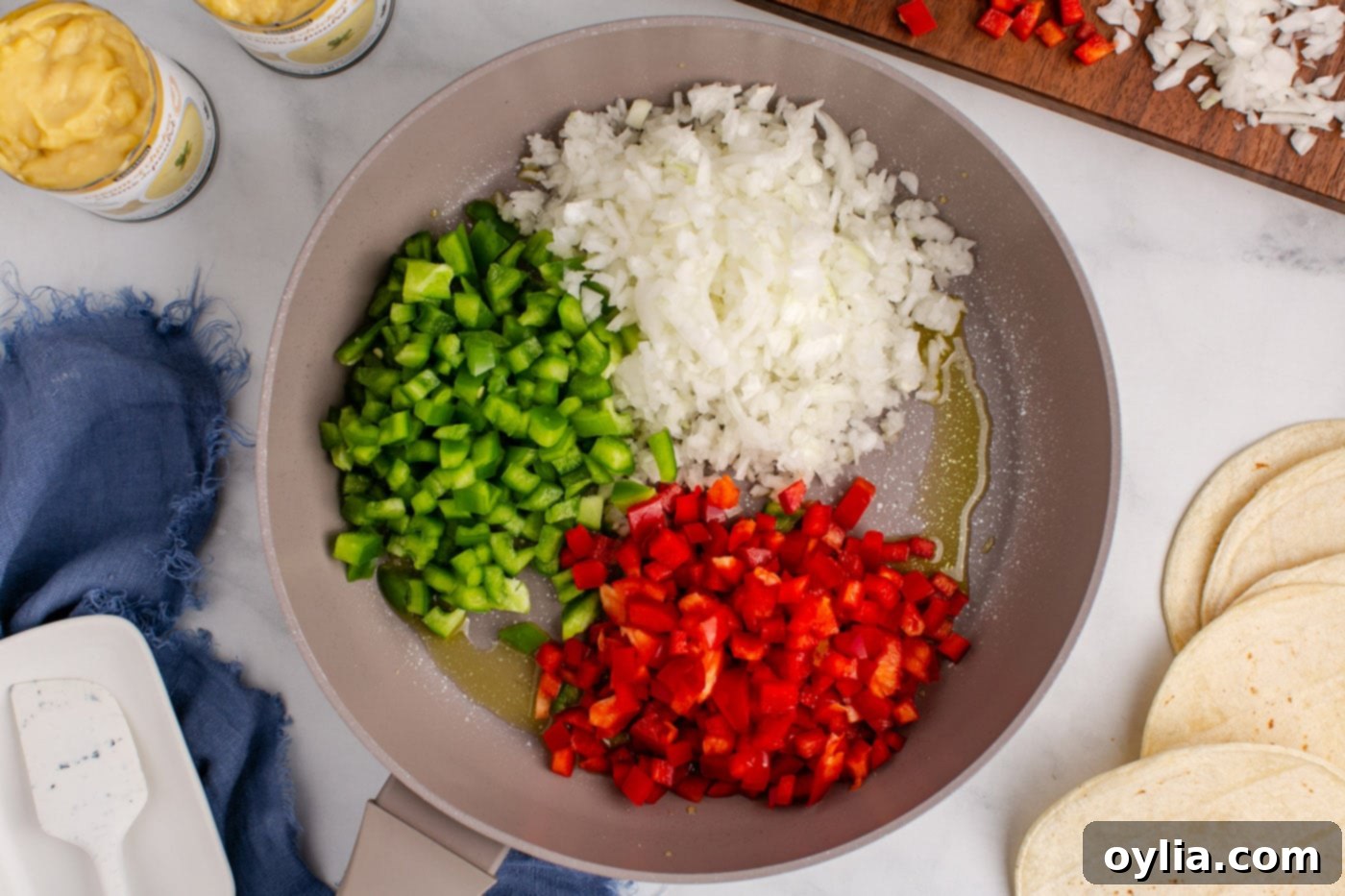 diced bell peppers and onion in a skillet with oil