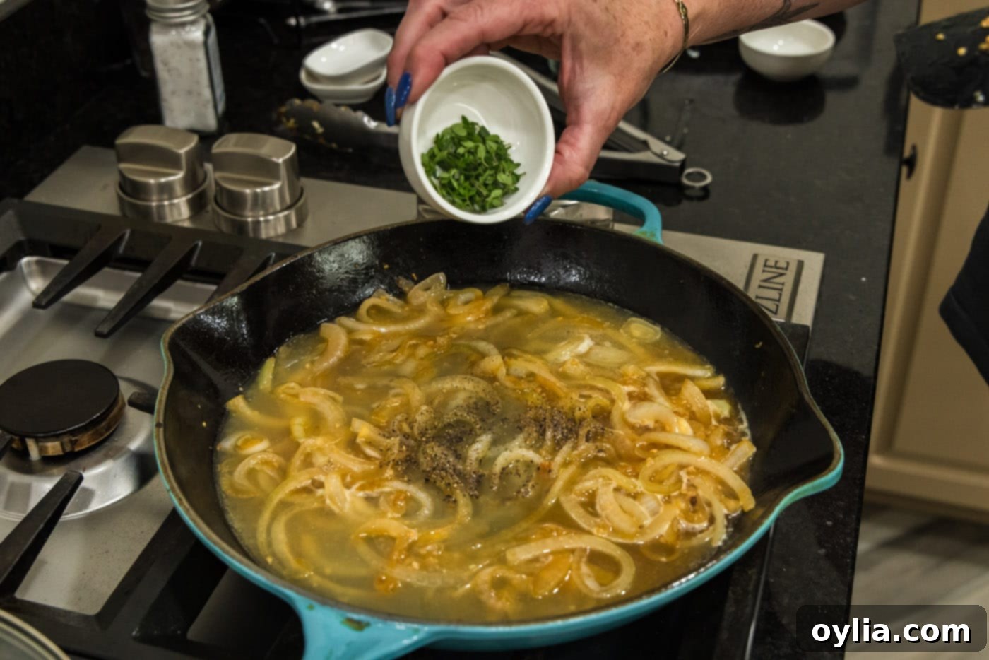adding fresh thyme leaves to skillet with onion sauce