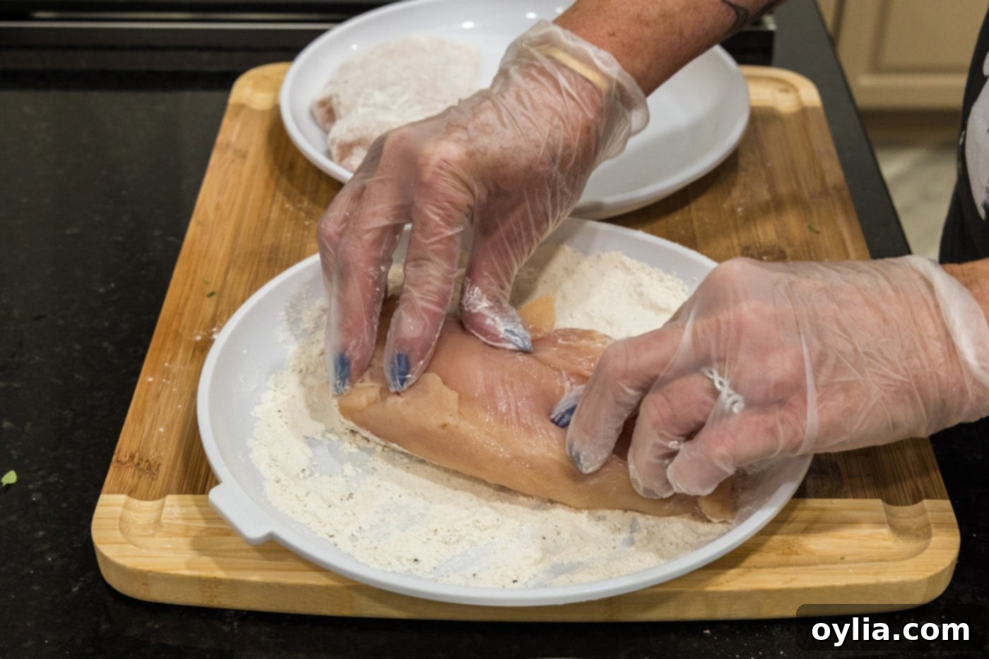 pressing chicken breasts into flour mixture