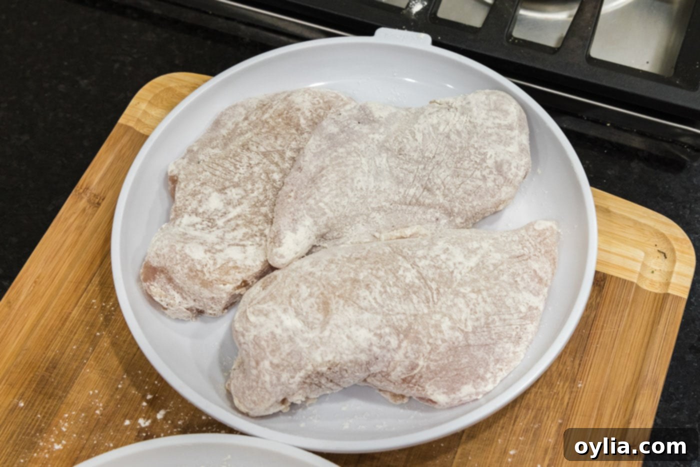 flour coated chicken breasts on a plate
