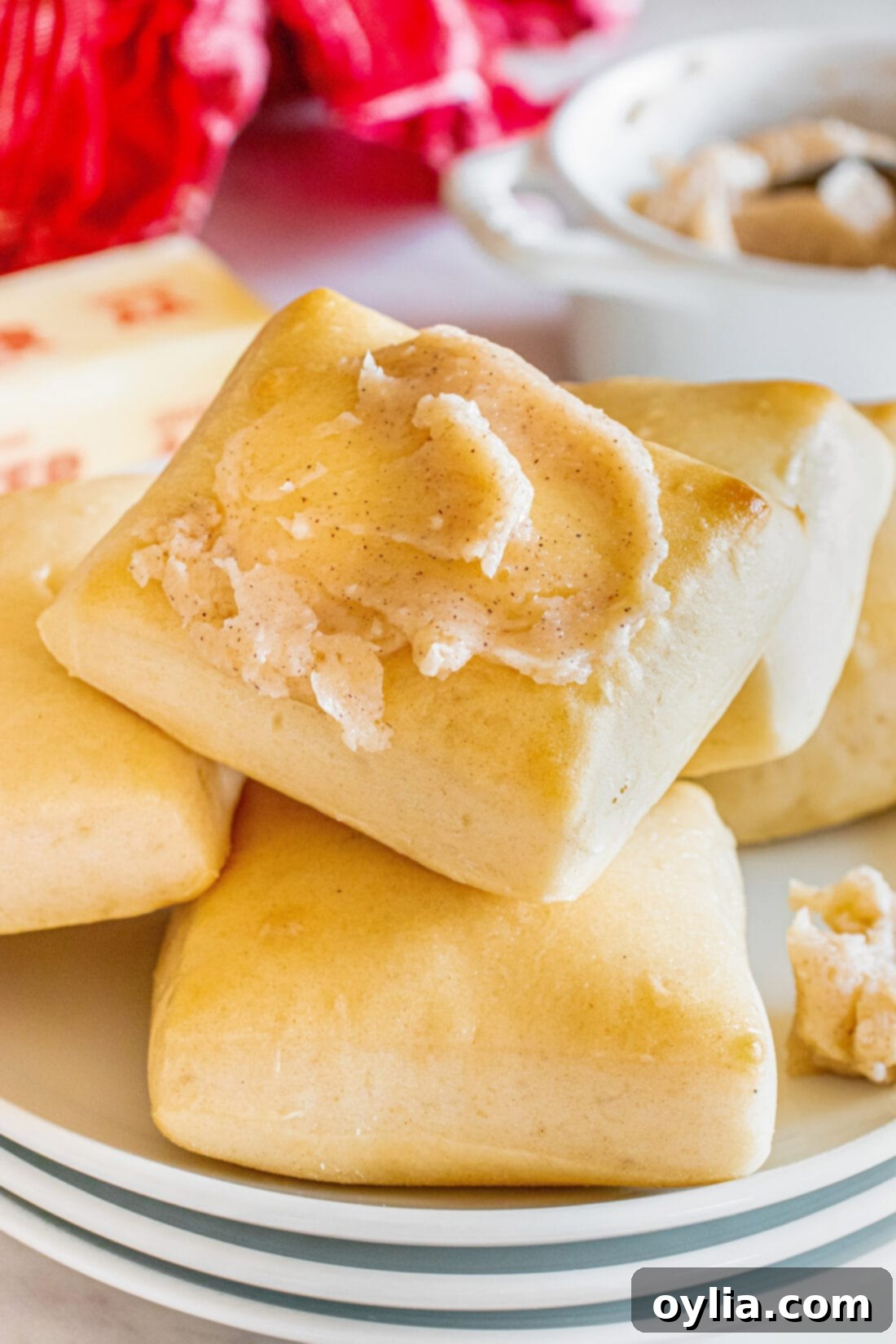 Close up photo of a Texas Roadhouse Roll topped with butter