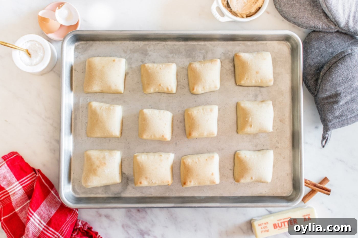baked square shaped dinner rolls on a baking sheet