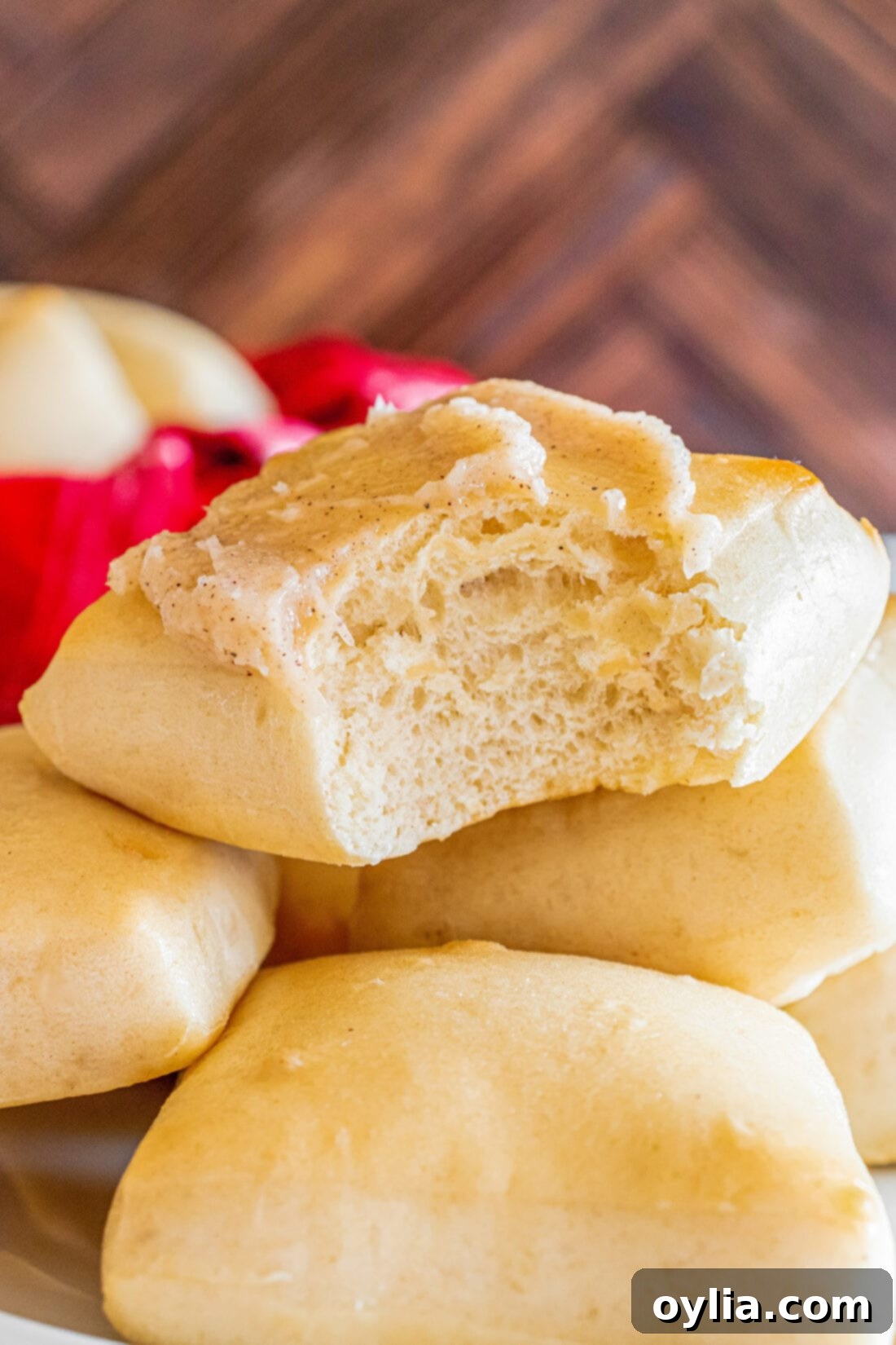 Close up photo of a Texas Roadhouse Roll topped with butter with a bite taken out, showing the fluffy interior