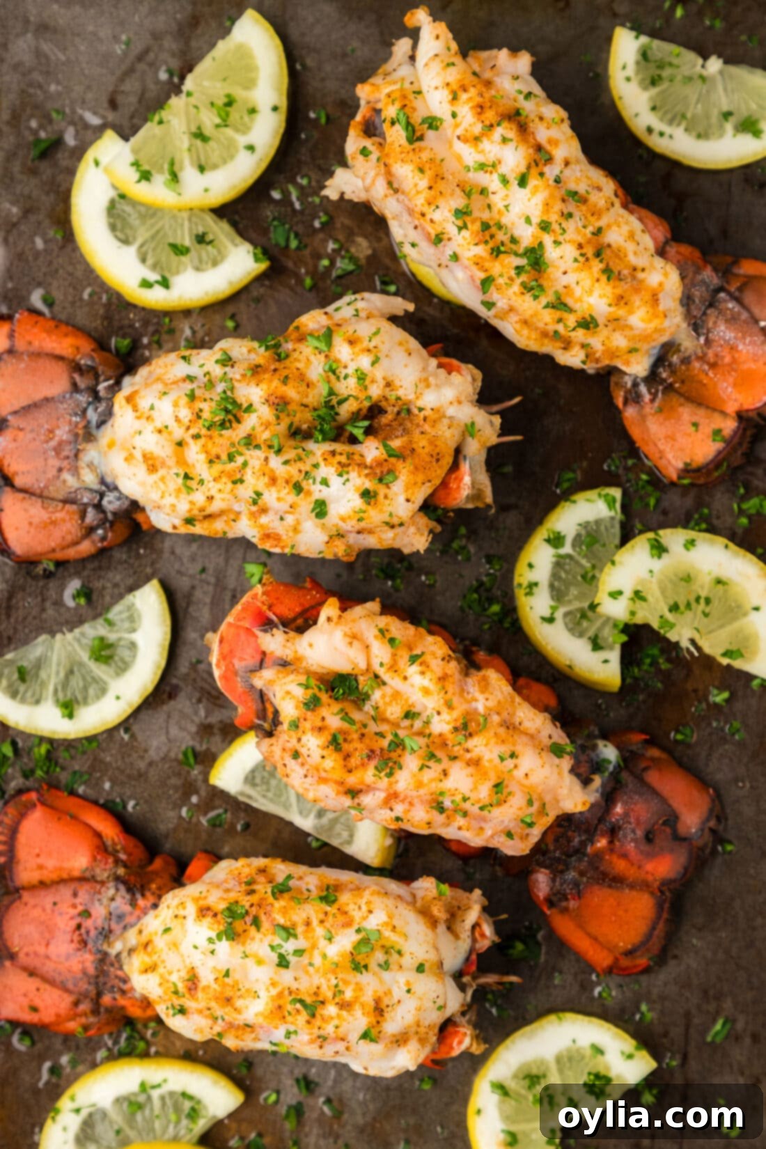 Baked Lobster Tails on a baking sheet with lemons