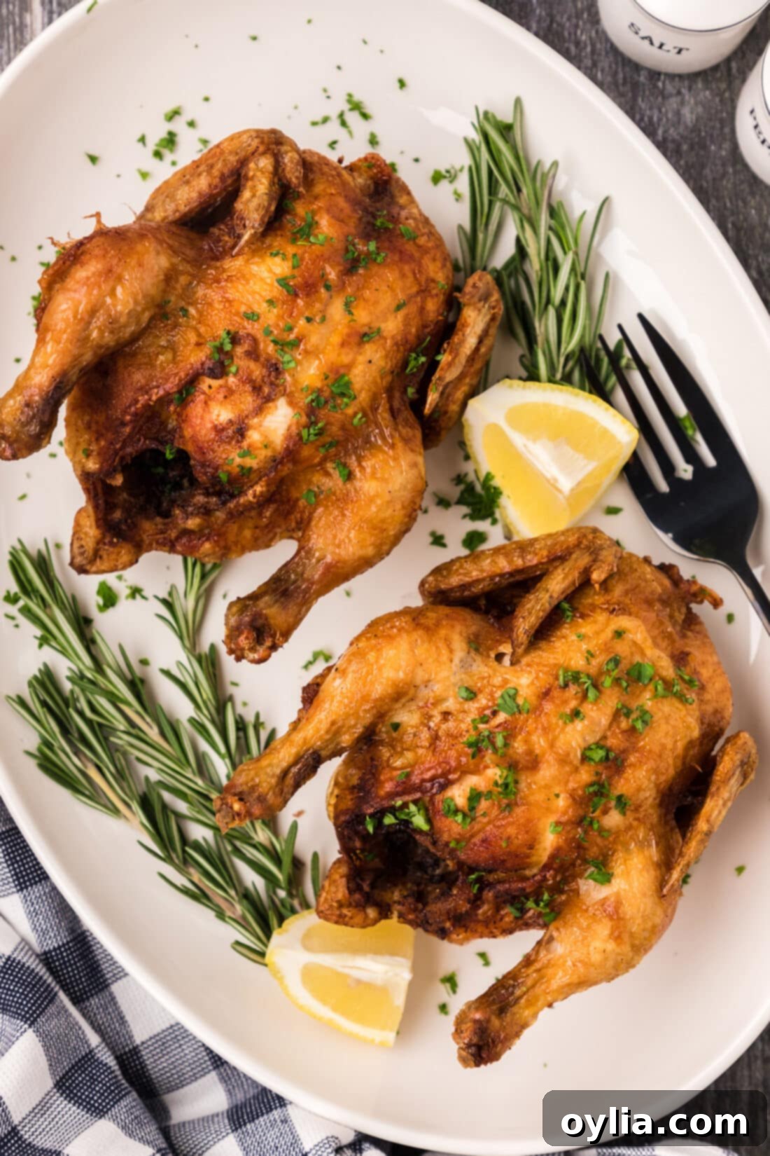 Southern Style Fried Cornish Hens 2 Deep Fried Cornish Hens on a platter with lemons and herbs