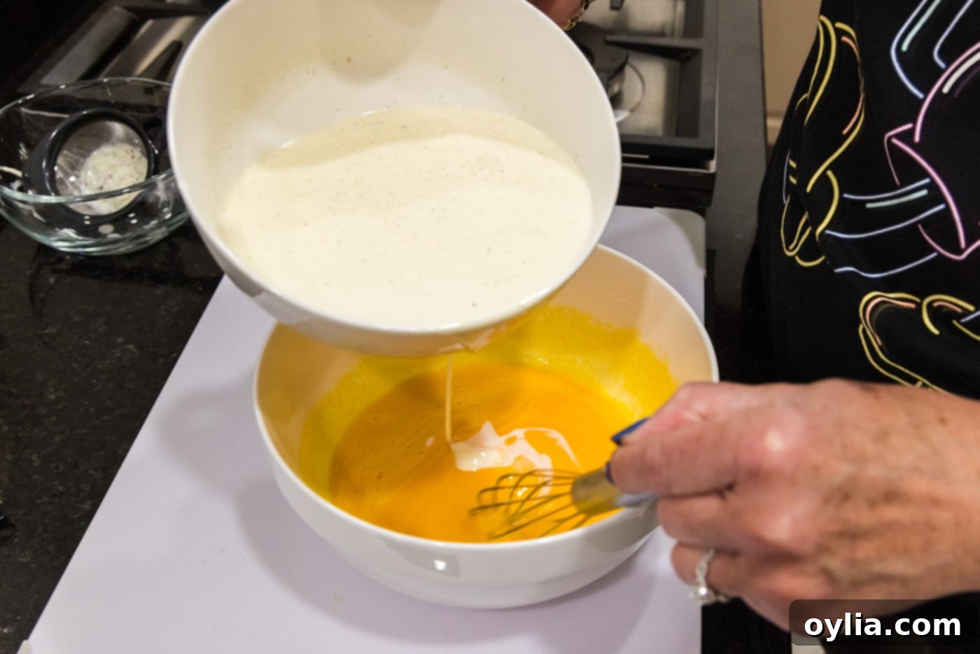 slowly whisking heavy cream mixture into egg yolks