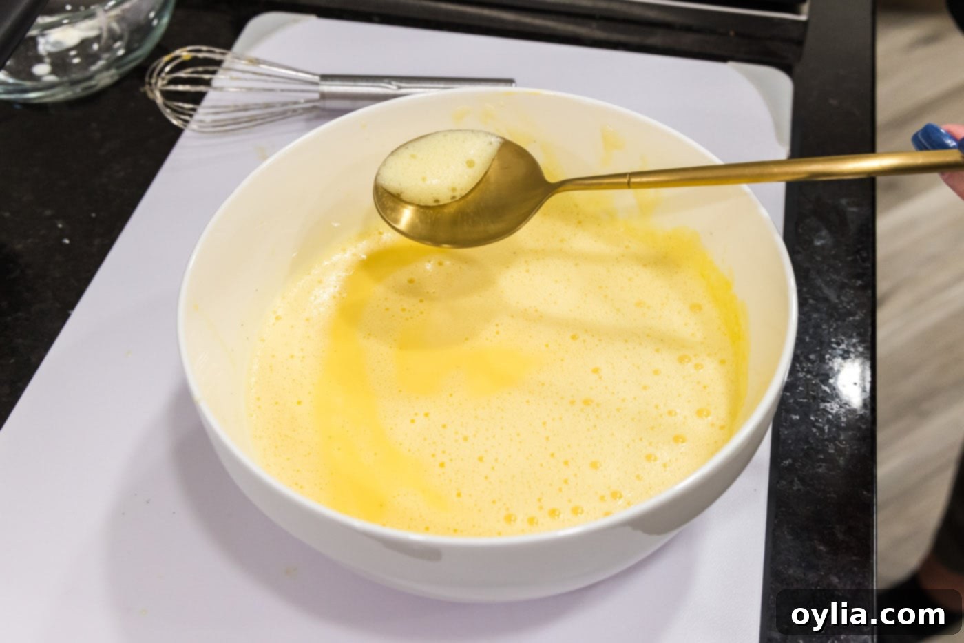 scooping froth from egg mixture