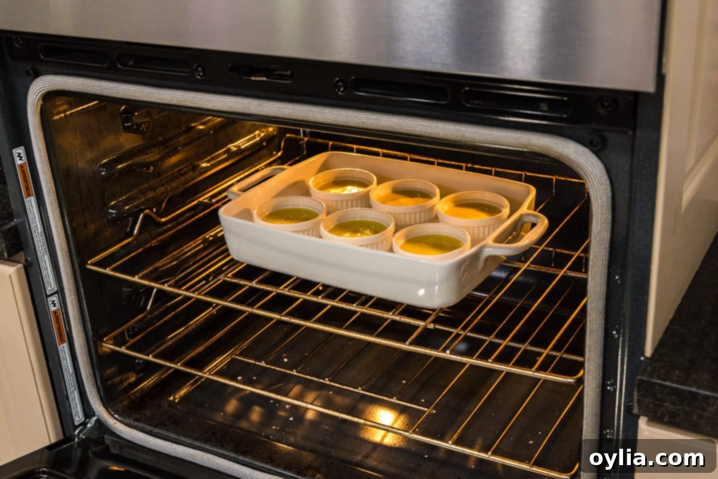 custard in ramekins placed in the oven in a baking dish