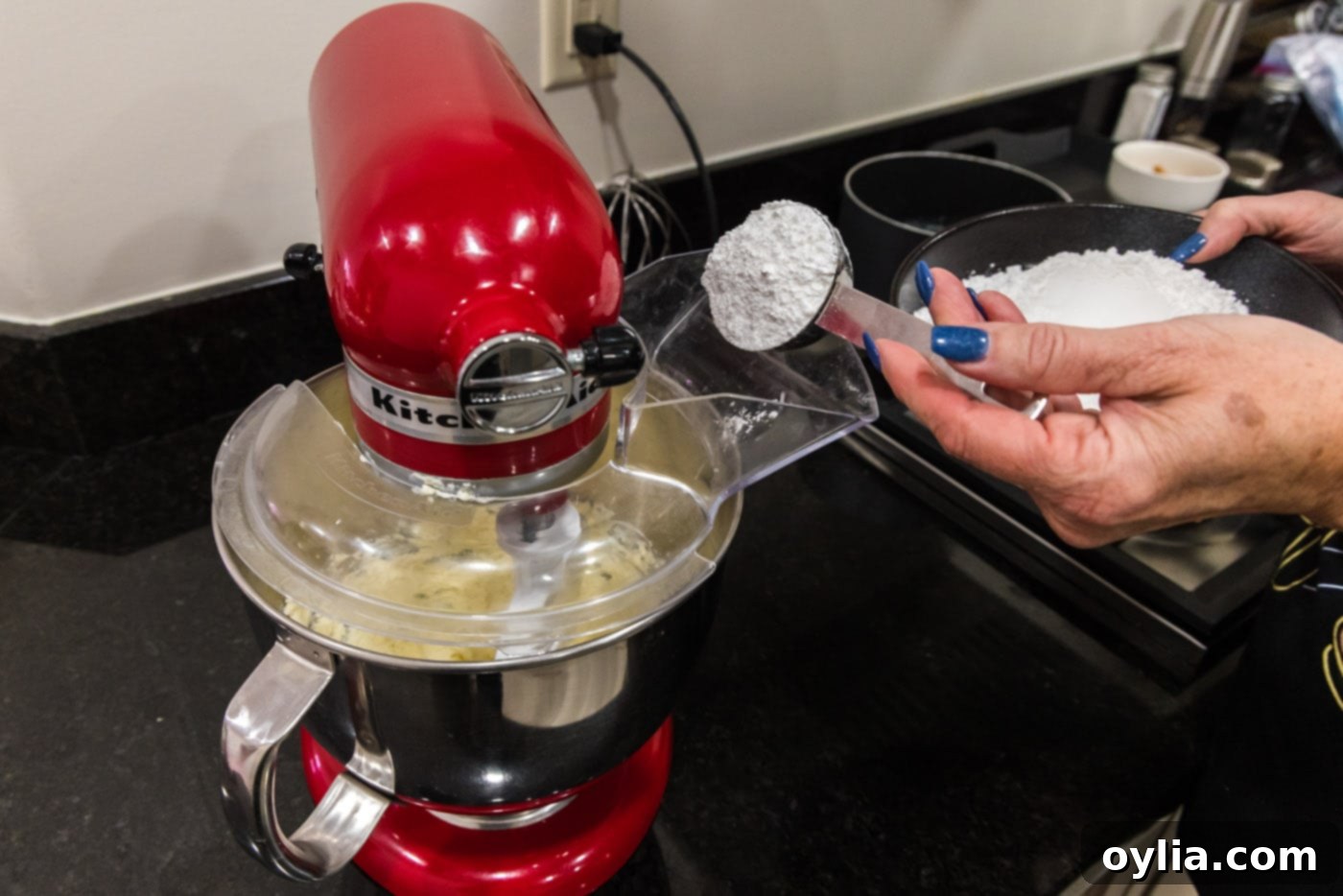 adding powdered sugar to butter and cream cheese mixture