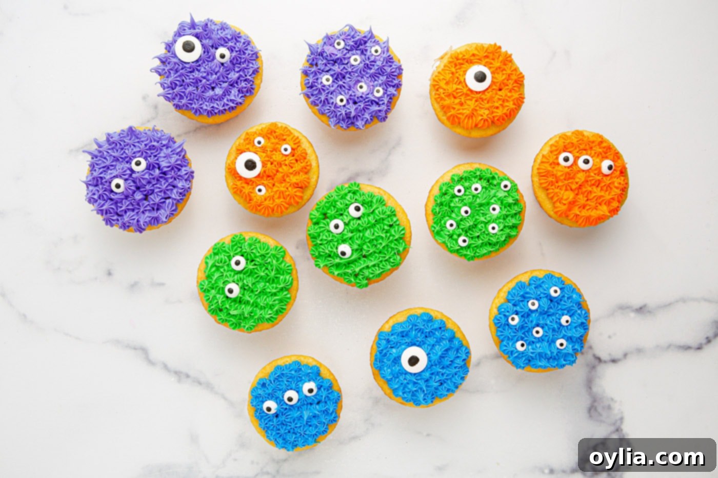 Decorating monster cupcakes with vibrant frosting and candy eyeballs.