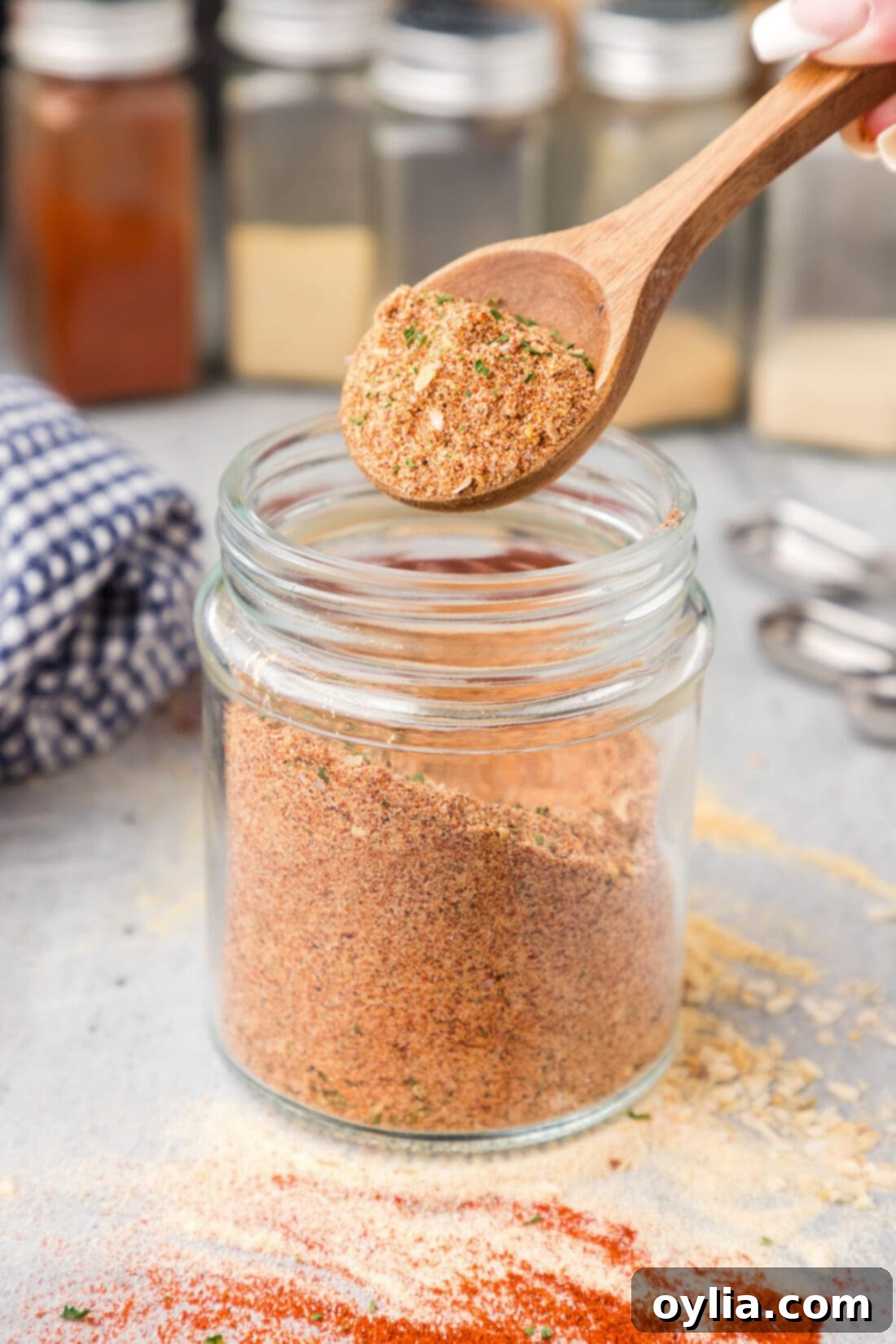 Spoonful of All Purpose Seasoning being lifted out of a jar, demonstrating its readiness for use