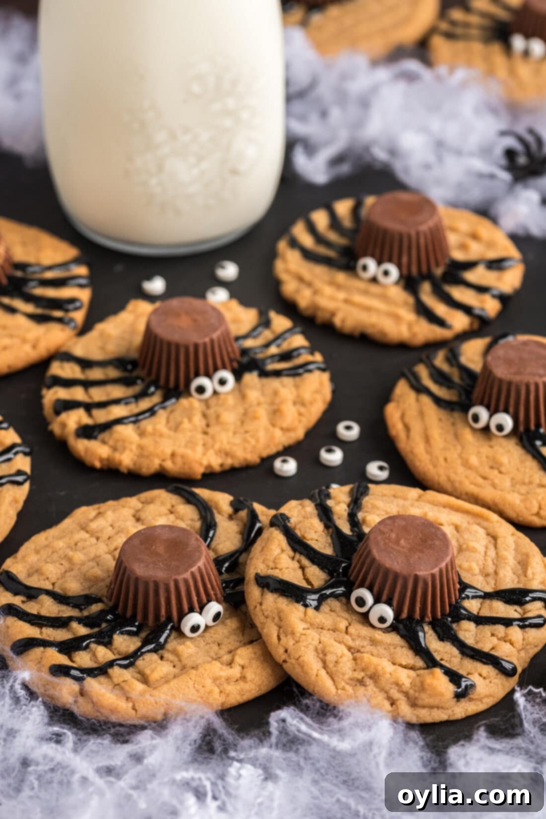 Spider Cookies on a platter with a jar of milk in the background, a sweet and spooky Halloween dessert