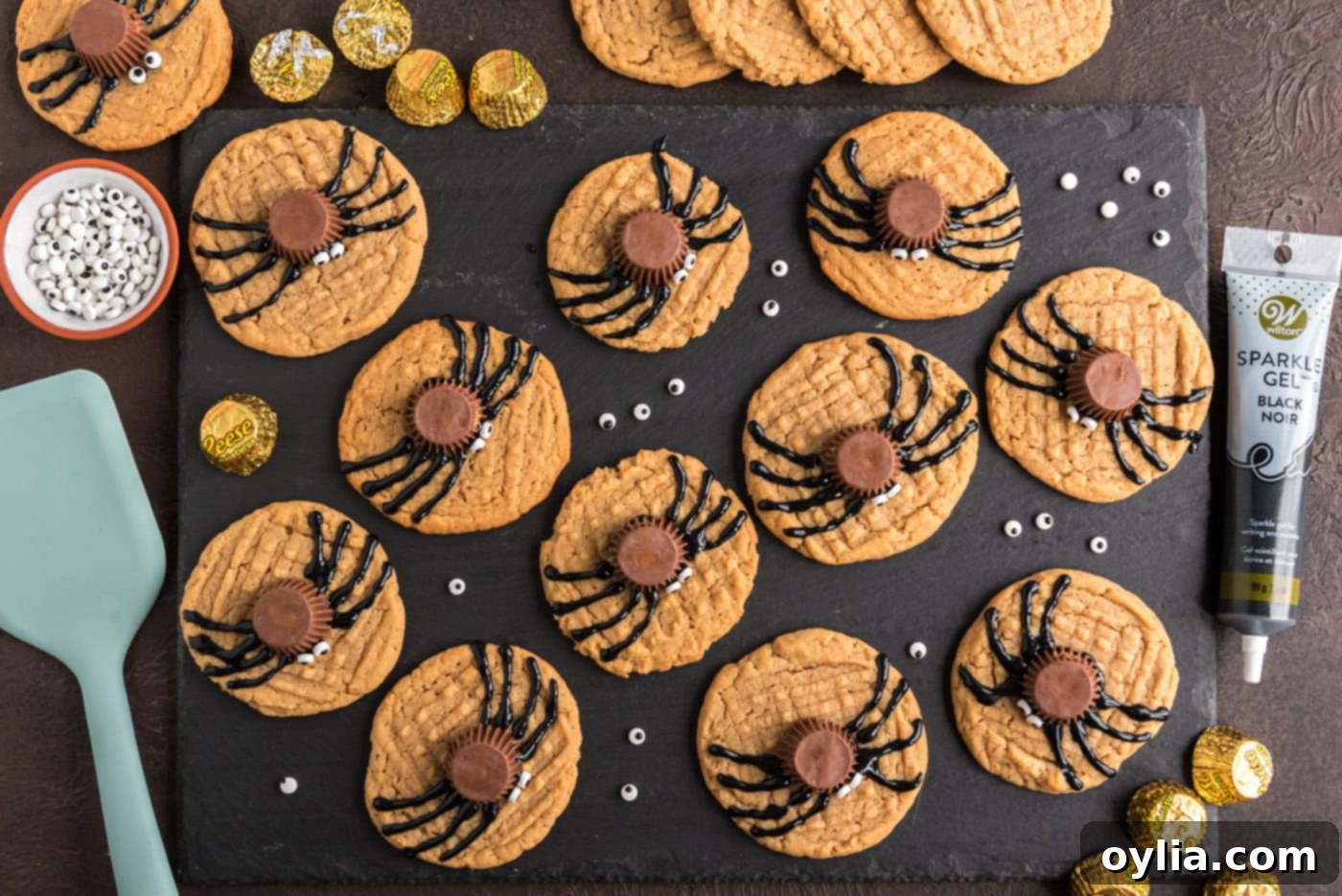 An overhead view of finished Halloween spider cookies, with Reese's bodies, candy eyes, and piped legs.