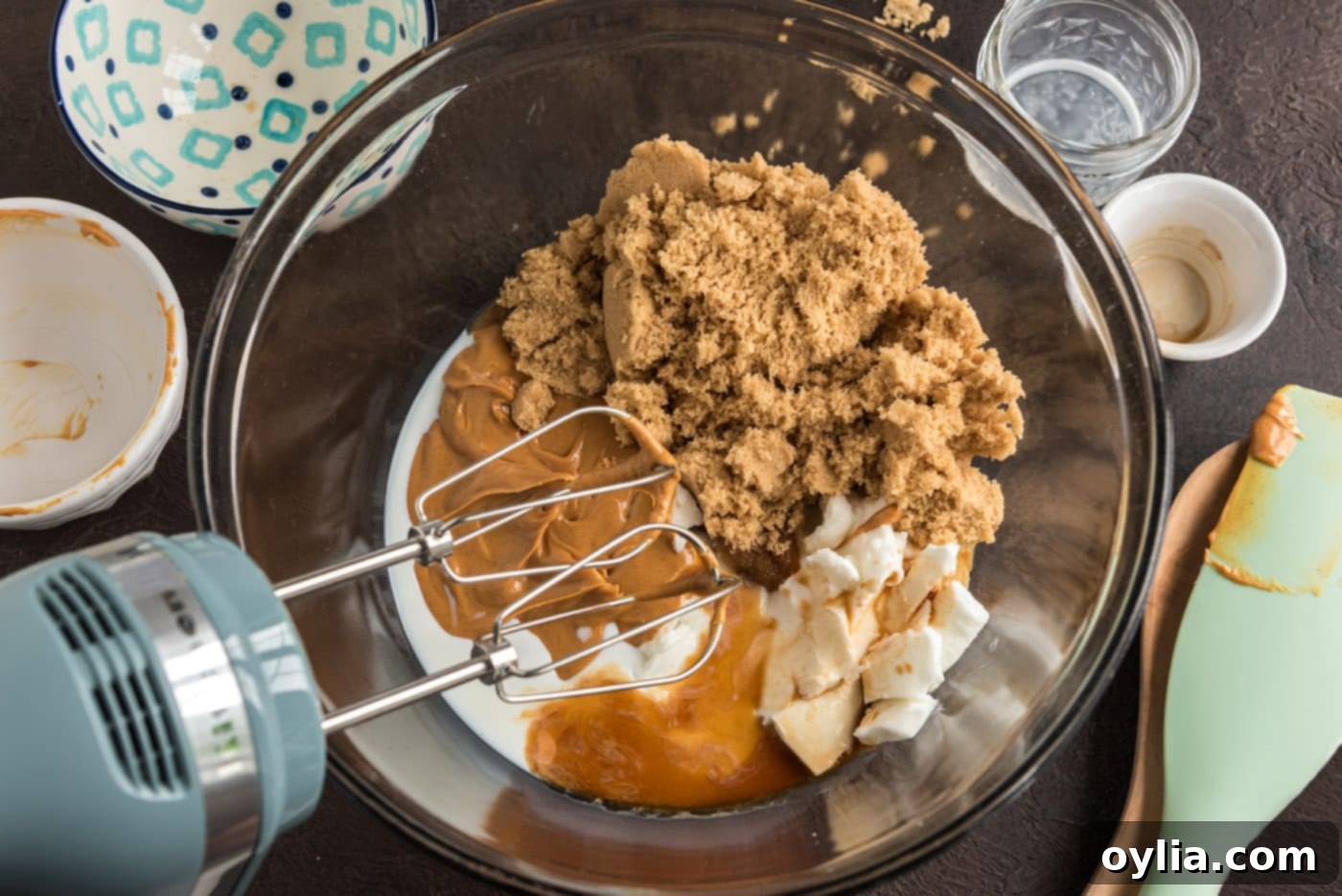 Peanut butter cookie ingredients in a bowl with an electric mixer starting to combine them.