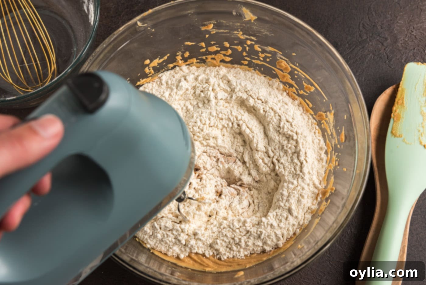 Dry ingredients (flour, salt, baking soda) being added to the wet peanut butter cookie mixture.