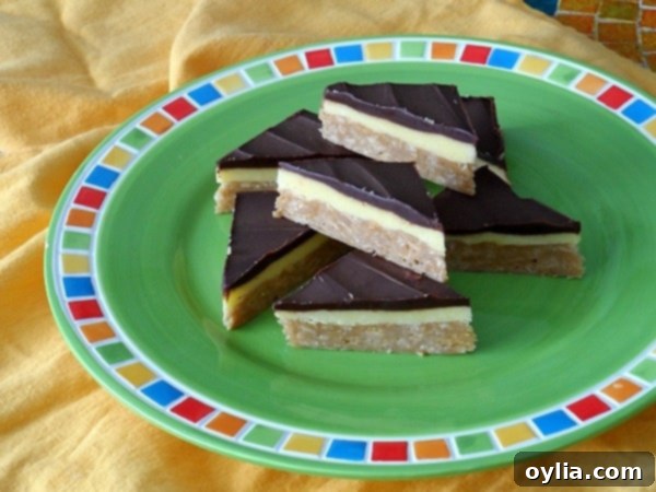 A close up photo of no bake peanut butter pudding bars resting on a green plate, showcasing multiple delicious layers.