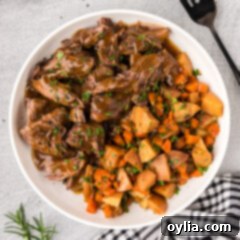 Bowl of Instant Pot Roast Beef with potatoes and carrots on the side