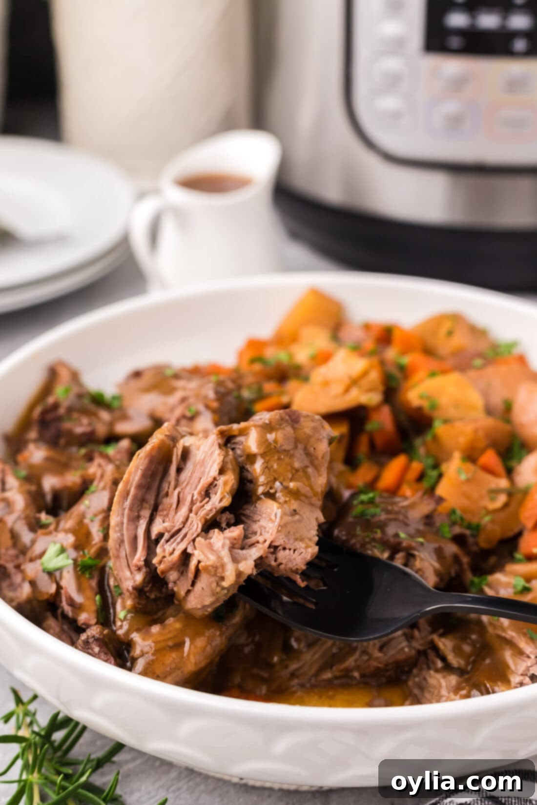 A close-up of a piece of tender Instant Pot Roast Beef on a fork, showing its juicy texture and perfect doneness.