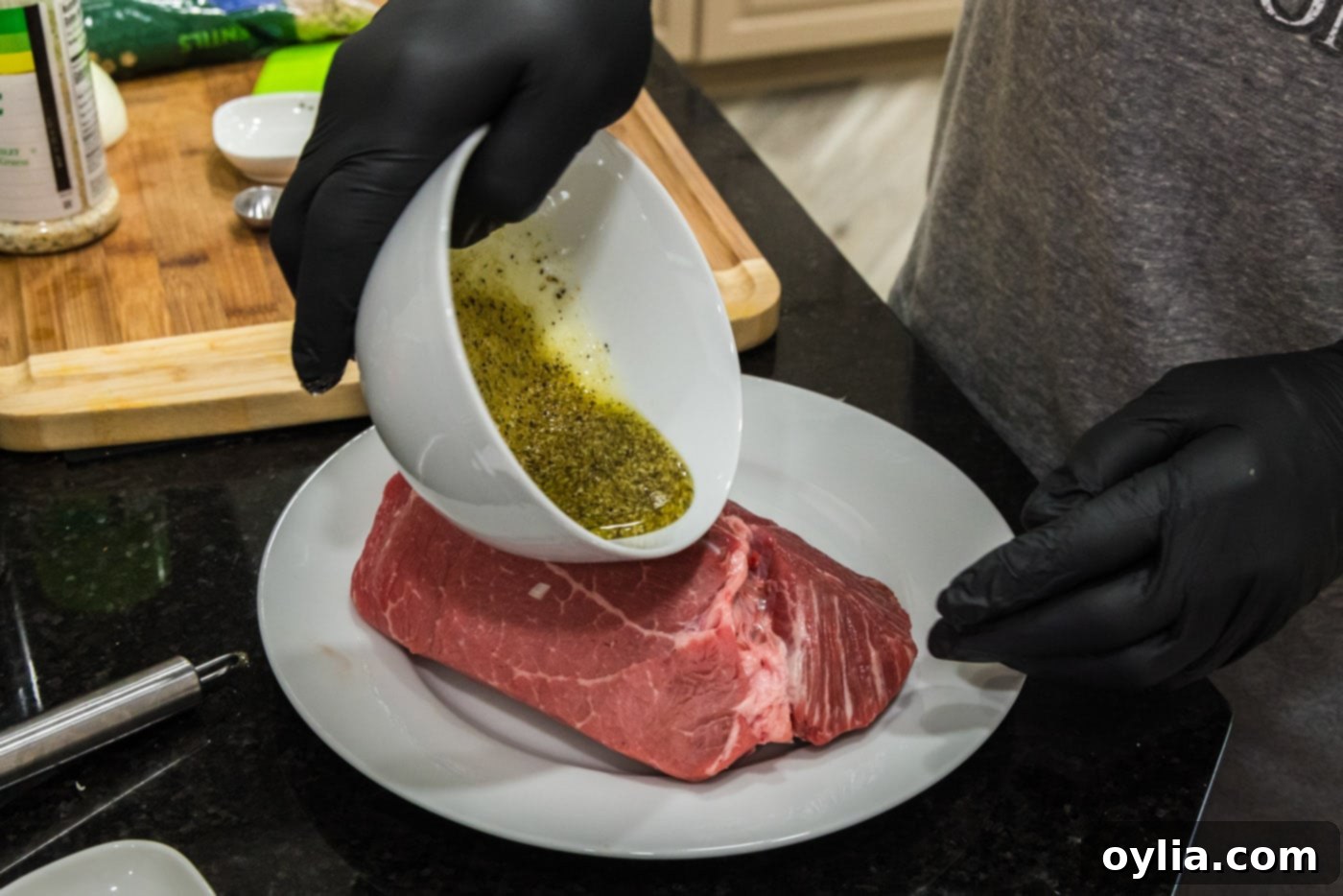 Applying a wet rub consisting of olive oil, garlic salt, and black pepper directly onto the sirloin tip roast before searing.