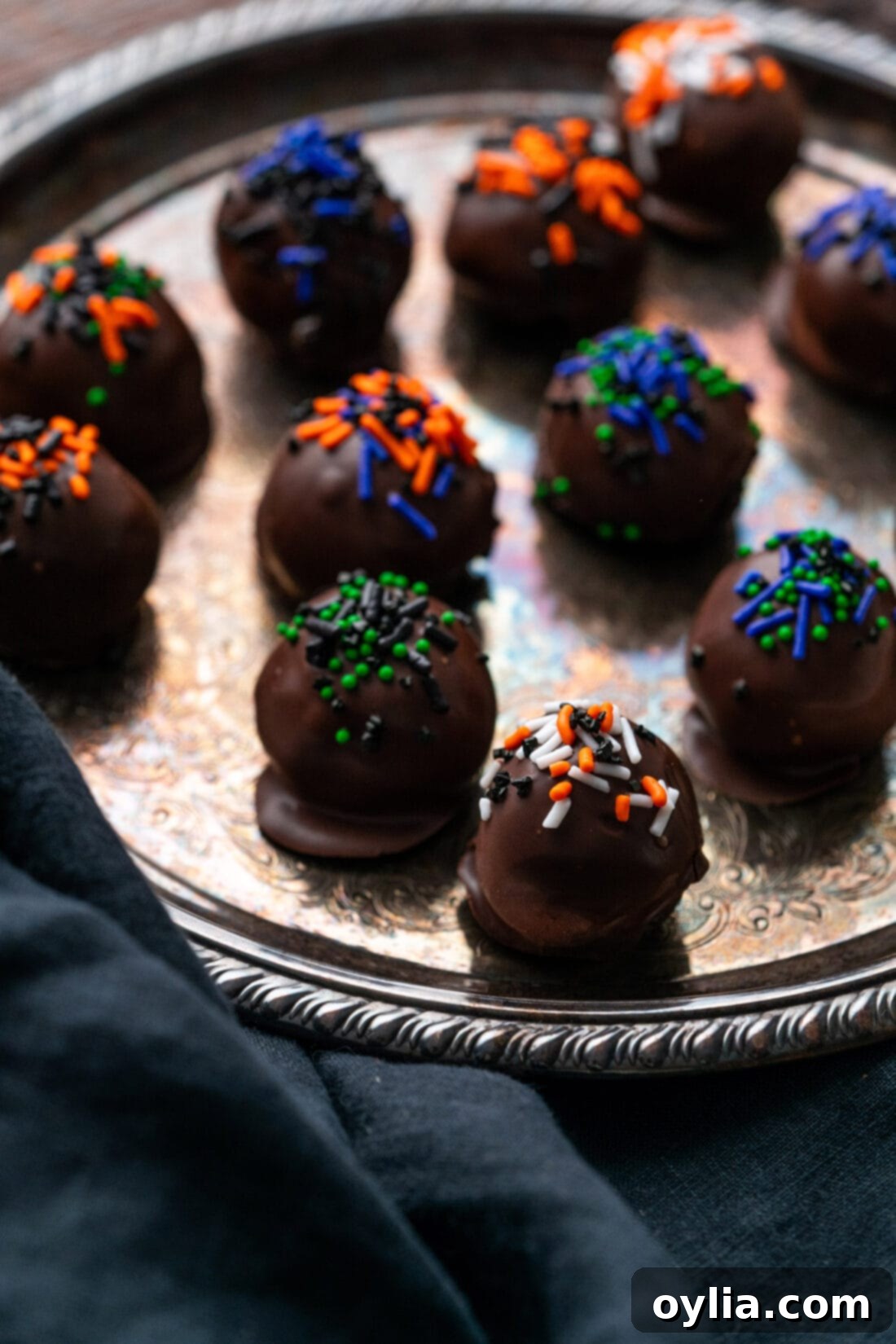Halloween Oreo Truffles on a silver platter, showing a mix of mummy, pumpkin, and sprinkle-decorated truffles.