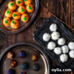 Assorted Halloween Oreo Truffles on decorative trays, showcasing mummy, pumpkin, and sprinkle designs.