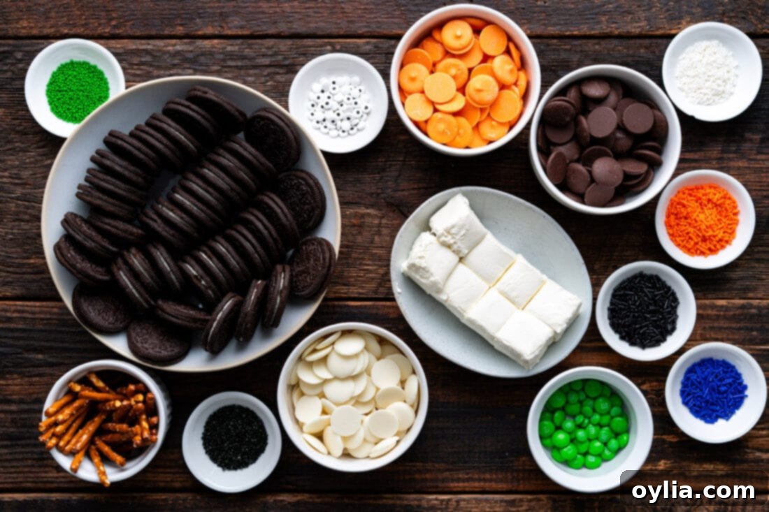 Ingredients for Halloween Oreo Truffles, including Oreo cookies, cream cheese, white, orange, and chocolate melting wafers, candy eyes, pretzel sticks, and M&M's.