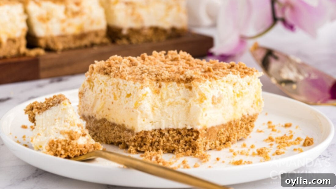 The fully assembled and chilled Pineapple Dream Dessert, with a slice removed, revealing its distinct layers.