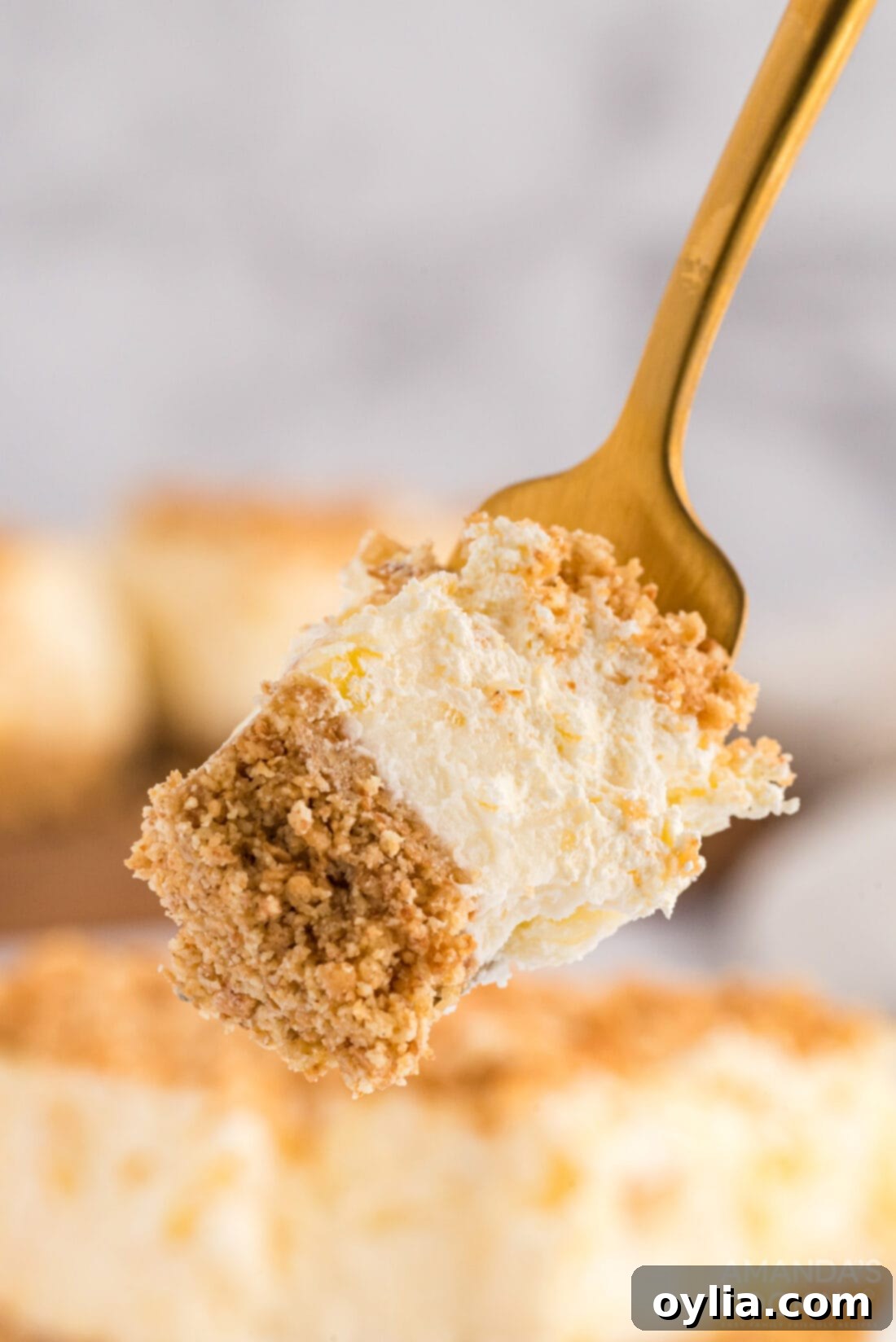 A fork lifting a delicious bite of Pineapple Dream Dessert, showcasing its multi-layered texture.