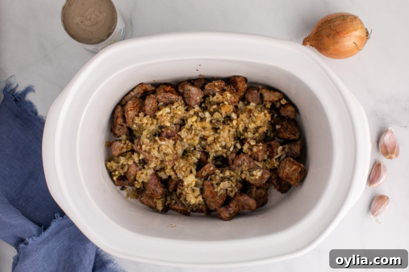onion mixture added to crockpot with beef stew meat