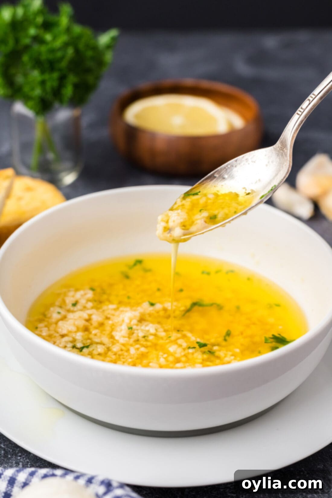 Spoon drizzling Garlic Butter Sauce into a bowl of Garlic Butter Sauce