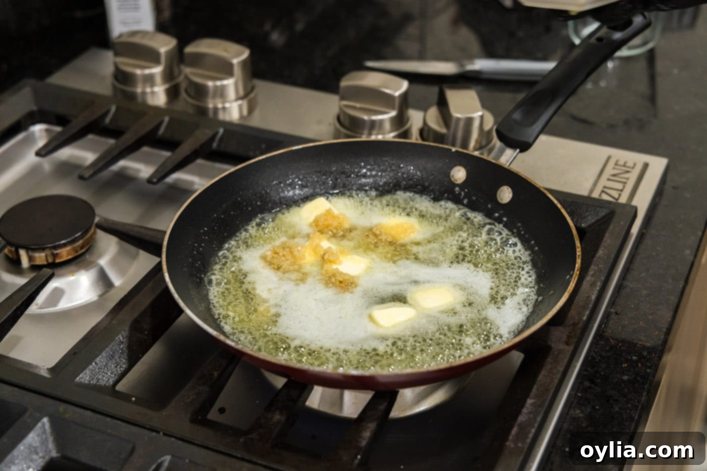 adding minced garlic to skillet of melted butter