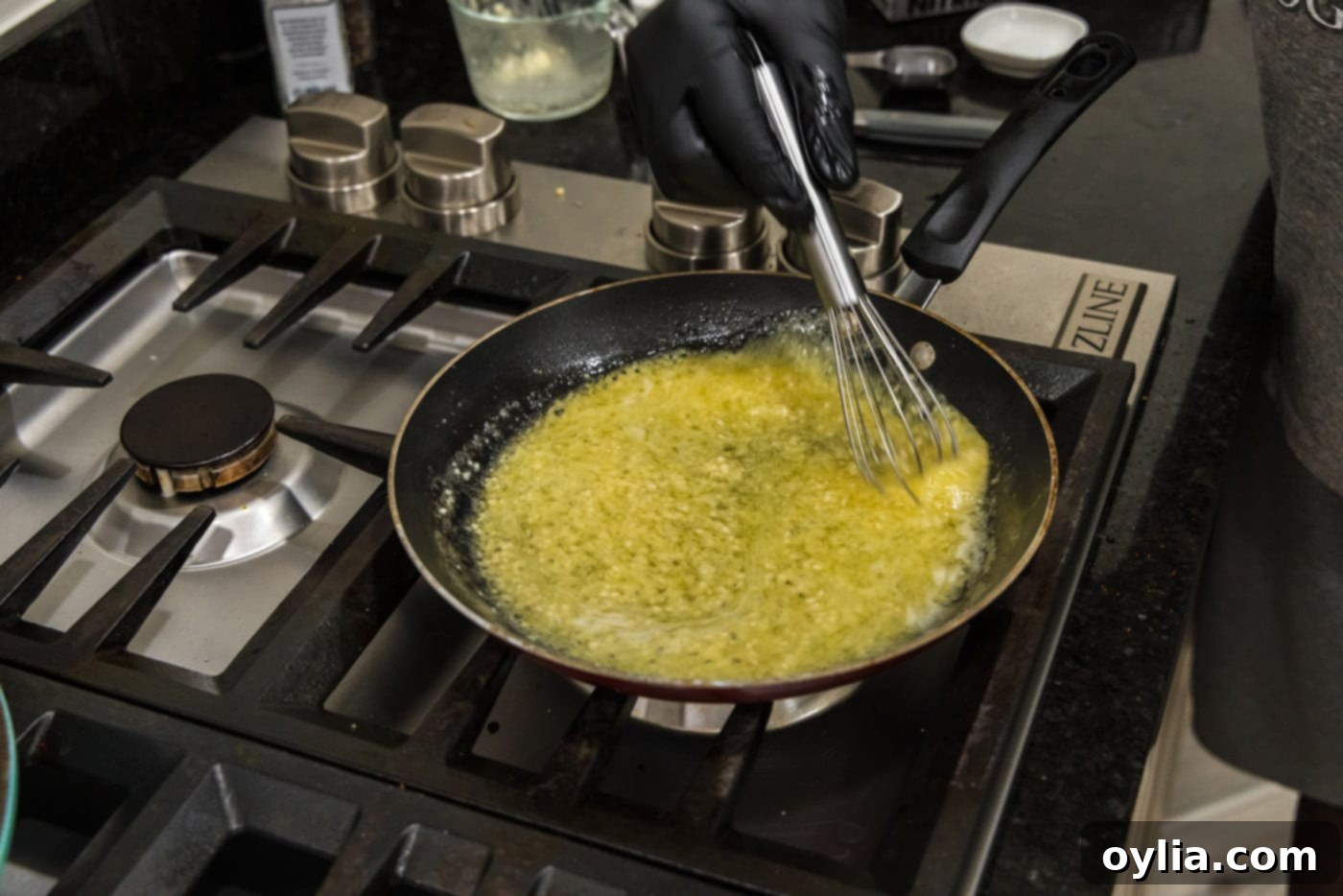 whisking garlic butter sauce in a skillet