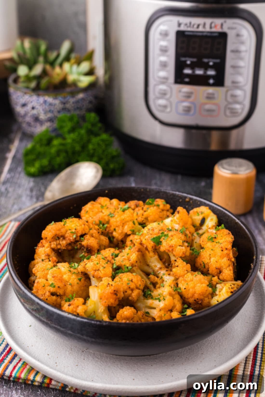 Bowl of Instant Pot Cauliflower with an Instant Pot in the background
