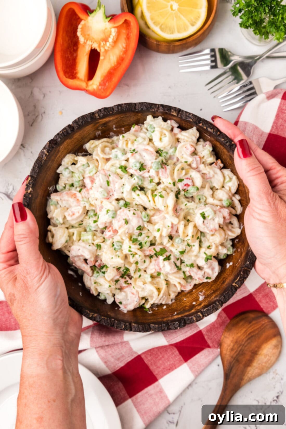 Hands holding a bowl of Shrimp Pasta Salad