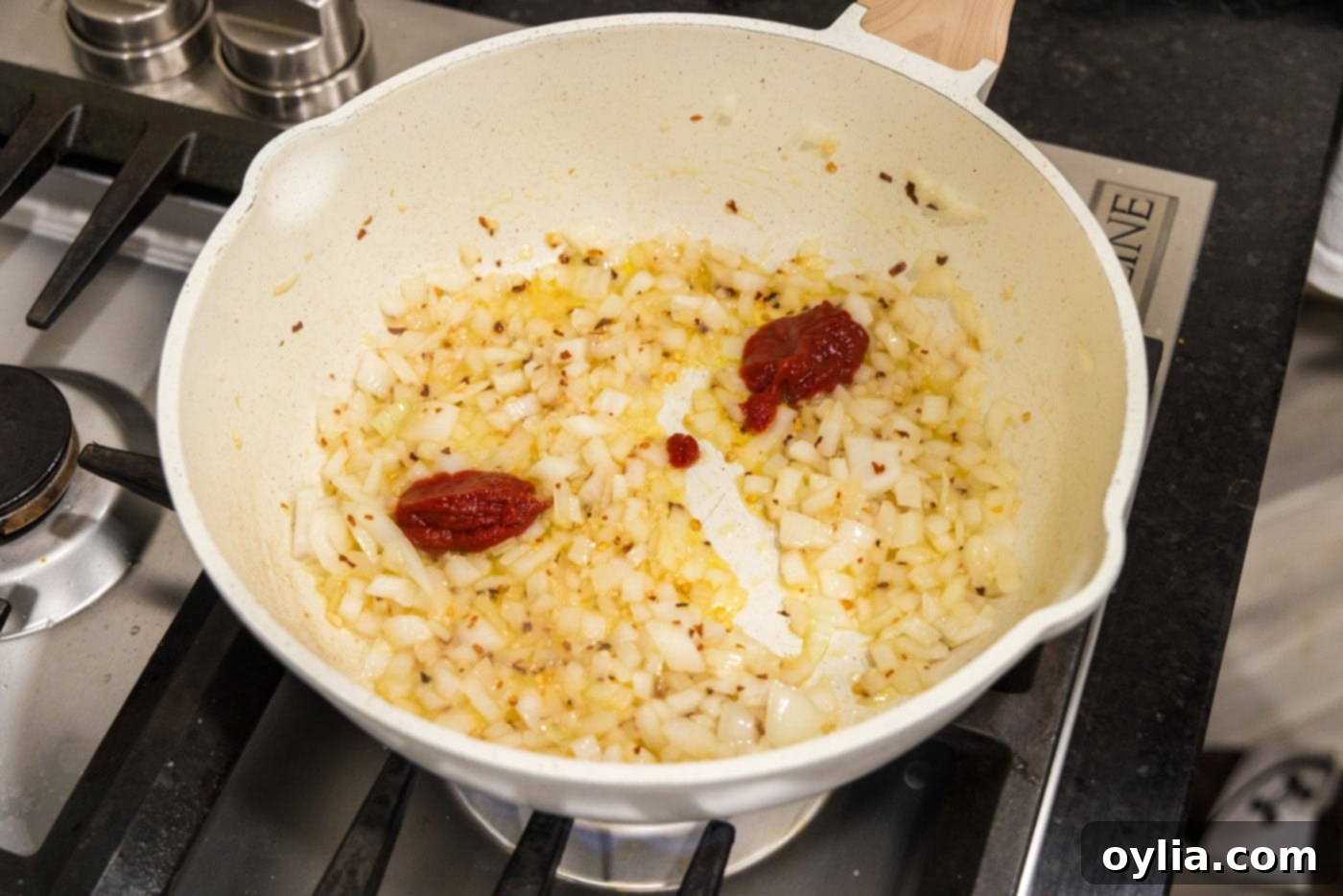 tomato pasta added to skillet of onion mixture