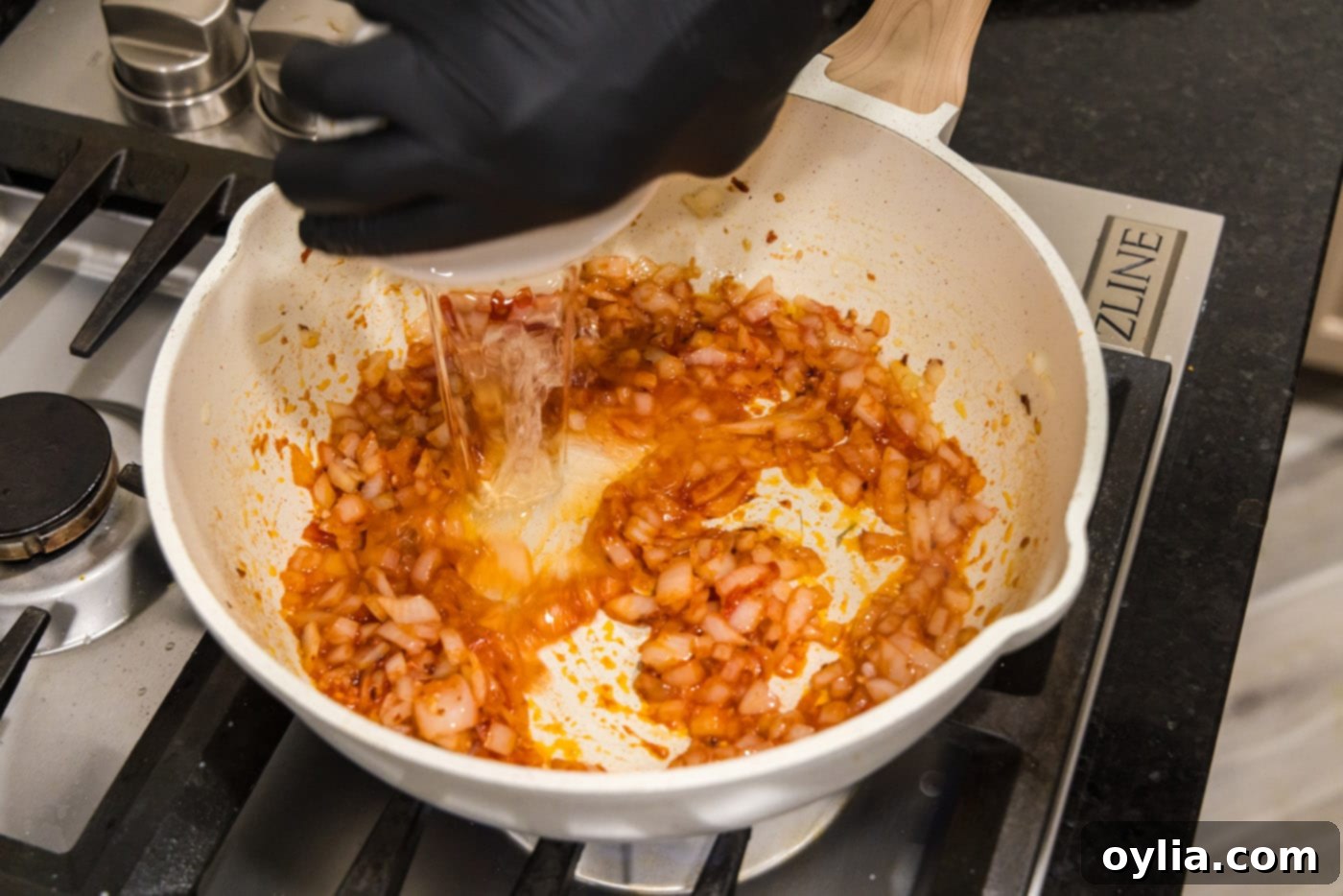 pouring vodka into tomato sauce