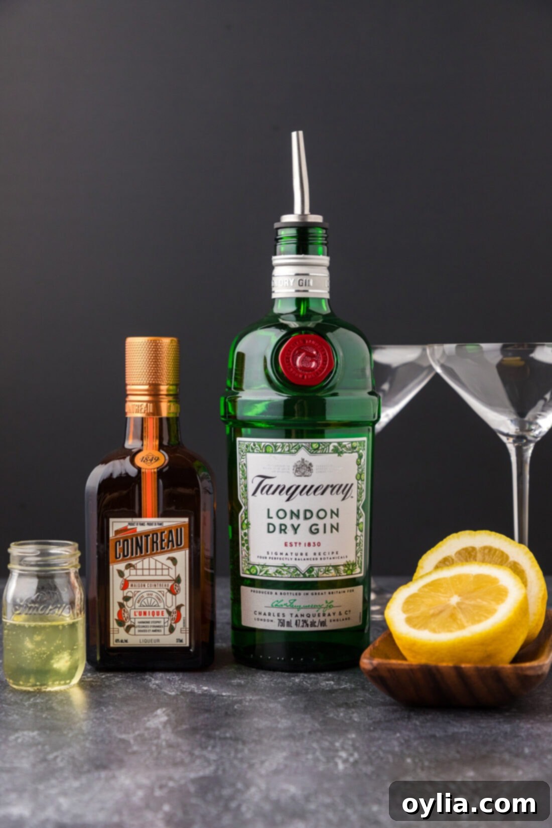 Collection of ingredients for making the White Lady Cocktail: gin, Cointreau, lemon, and egg