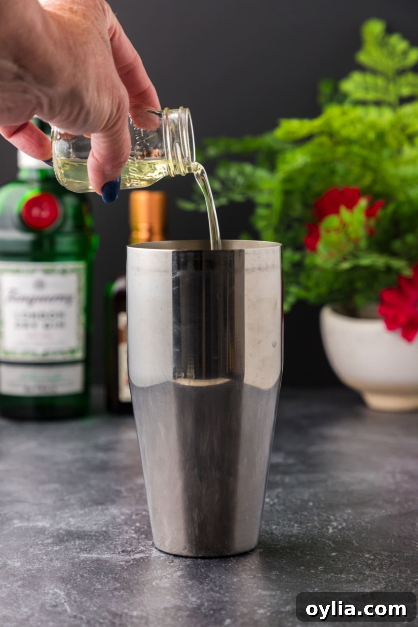Pouring egg whites into a cocktail shaker as the first step for a White Lady Cocktail