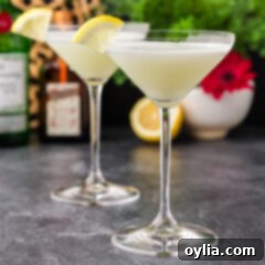 Close up photo of two White Lady Cocktails with their creamy foam tops and lemon garnishes