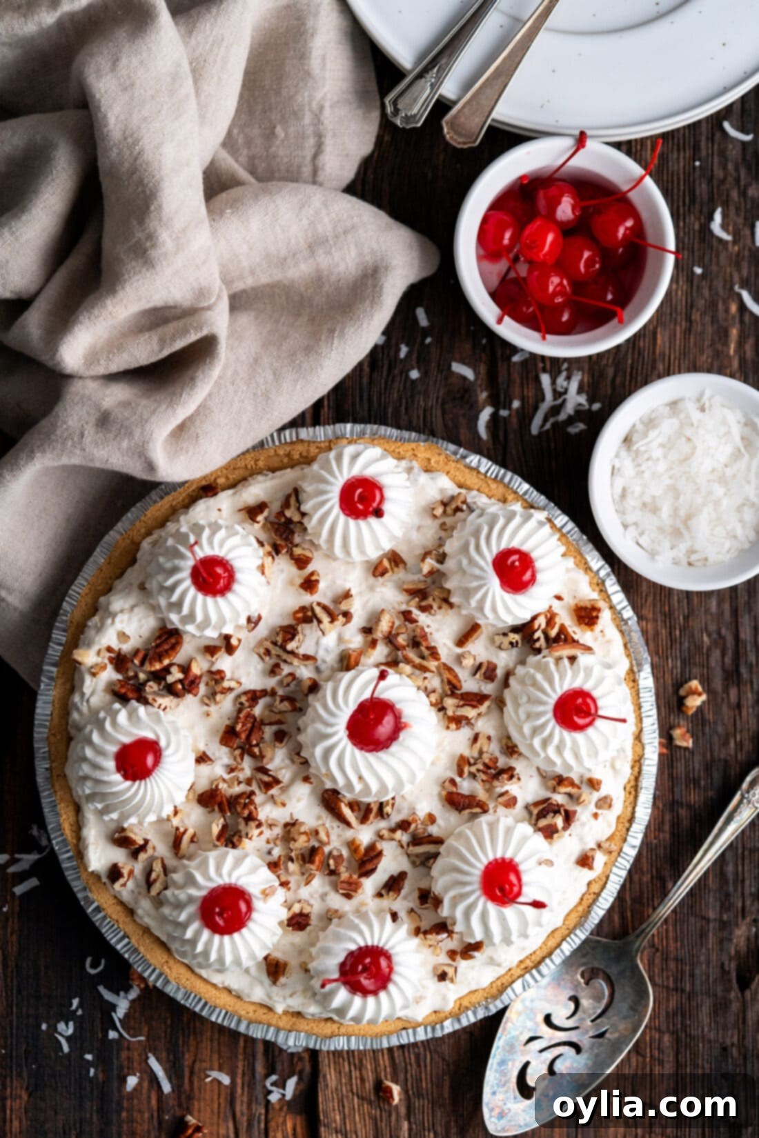 Million Dollar Pie with a bowl of cherries and shredded coconut on the side, a perfect no-bake dessert.