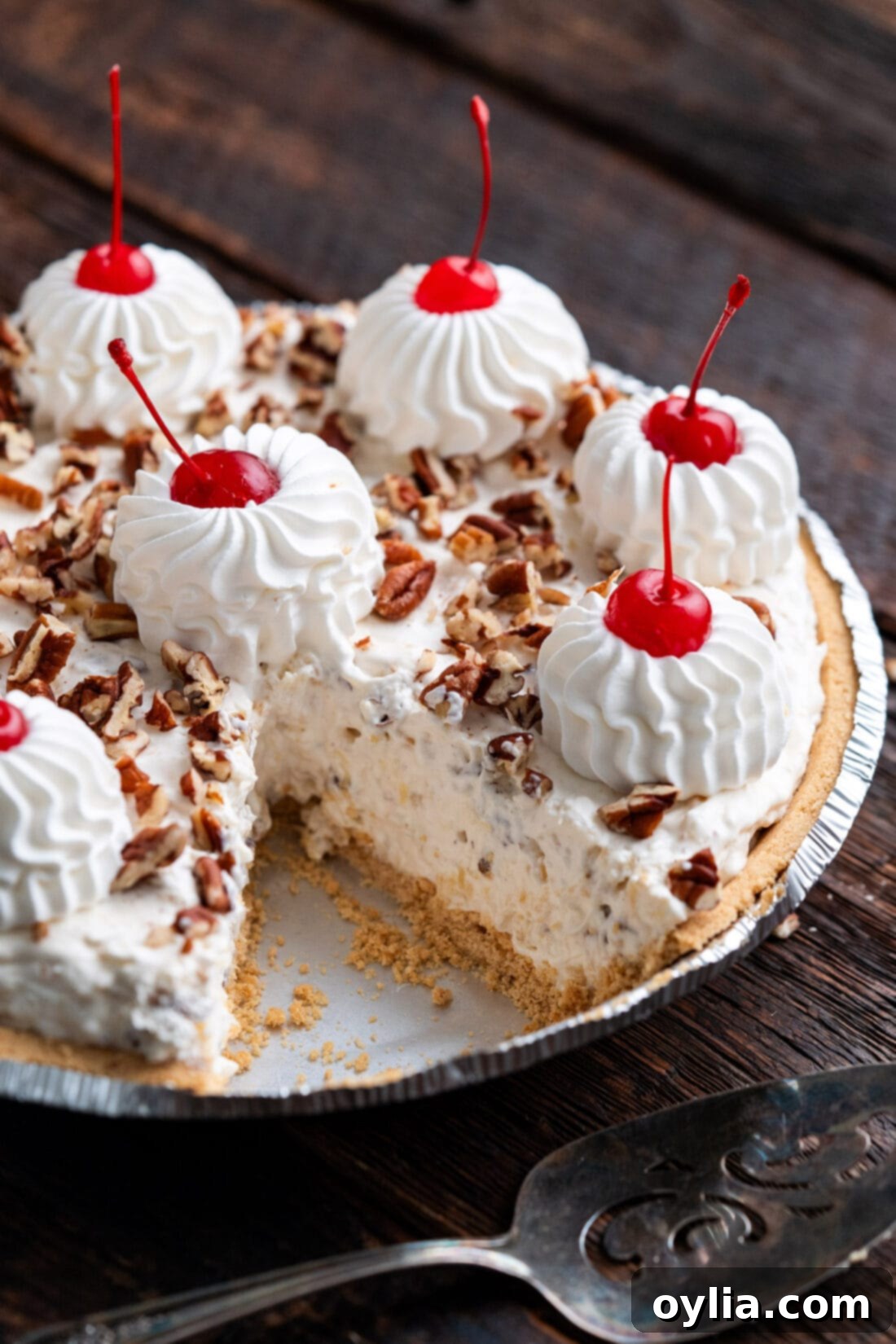 A perfectly sliced No-Bake Million Dollar Pie on a serving plate, showing its creamy layers.